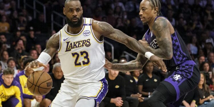 Los Angeles Lakers forward LeBron James (23) drives the ball past Sacramento Kings forward DeMar DeRozan, right, during the first half of an NBA basketball game Saturday, Oct. 26, 2024, in Los Angeles. (AP Photo/William Liang)