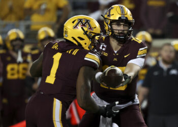 Minnesota quarterback Max Brosmer, right, hands the ball off to running back Darius Taylor (1) during the first half of an NCAA college football game against Southern California, Saturday, Oct. 5, 2024, in Minneapolis. (AP Photo/Ellen Schmidt)