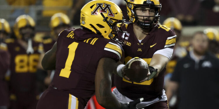 Minnesota quarterback Max Brosmer, right, hands the ball off to running back Darius Taylor (1) during the first half of an NCAA college football game against Southern California, Saturday, Oct. 5, 2024, in Minneapolis. (AP Photo/Ellen Schmidt)