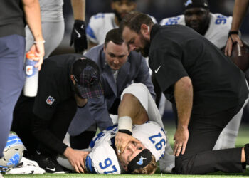 Detroit Lions defensive end Aidan Hutchinson (97) is attended to by team staff after suffering an unknown injury second half of an NFL football game against the Dallas Cowboys in Arlington, Texas, Sunday, Oct. 13, 2024. (AP Photo/Jerome Miron)