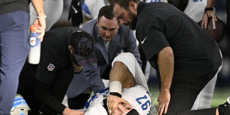 Detroit Lions defensive end Aidan Hutchinson (97) is attended to by team staff after suffering an unknown injury second half of an NFL football game against the Dallas Cowboys in Arlington, Texas, Sunday, Oct. 13, 2024. (AP Photo/Jerome Miron)