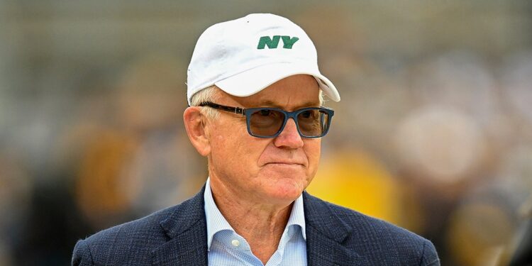 Woody Johnson looks on field