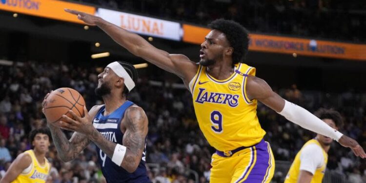 Minnesota Timberwolves guard Nickeil Alexander-Walker, center, shoots as Los Angeles Lakers.