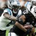 Las Vegas Raiders wide receiver Davante Adams is tackled by Carolina Panthers cornerback Jaycee Horn.