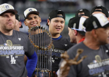 Shohei Ohtani helped his teammates get to the World Series, and his teammates got him to the finish line. (Photo by Elsa/Getty Images)