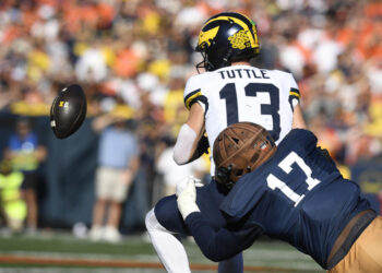 CHAMPAIGN, IL - OCTOBER 19: Michigan Wolverines Quarterback Jack Tuttle (13) fumbles the ball during the college football game between the Michigan Wolverines and the Illinois Fighting Illini on October 19, 2024, at Memorial Stadium, in Champaign, Illinois. (Photo by Michael Allio/Icon Sportswire via Getty Images)