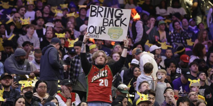 A fan hold up a sign in the stands urging the former Seattle Sonics basketball team to return to Seattle before a preseason NBA basketball game between the Los Angeles Clippers and the Portland Trail Blazers, Friday, Oct. 11, 2024, in Seattle. (AP Photo/John Froschauer)