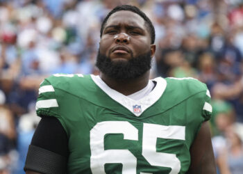 NASHVILLE, TN - SEPTEMBER 15: Xavier Newman #65 of the New York Jets looks on from the sideline during the national anthem prior to an NFL football game against the Tennessee Titans at Nissan Stadium on September 15, 2024 in Nashville, TN. (Photo by Perry Knotts/Getty Images)