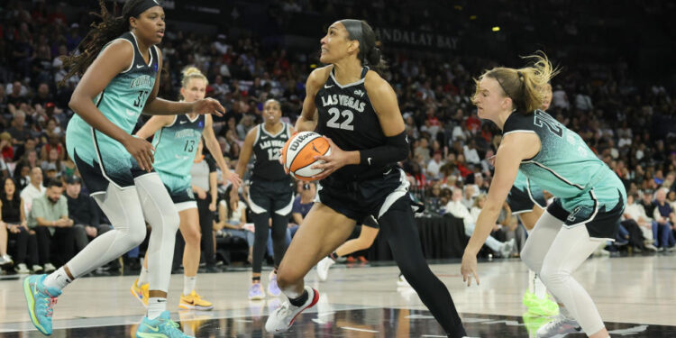 LAS VEGAS, NEVADA - OCTOBER 04: A'ja Wilson #22 of the Las Vegas Aces drives to the basket against Jonquel Jones #35 and Sabrina Ionescu #20 of the New York Liberty in the second quarter of Game Three of the 2024 WNBA Playoffs semifinals at Michelob ULTRA Arena on October 04, 2024 in Las Vegas, Nevada. The Aces defeated the Liberty 95-81. NOTE TO USER: User expressly acknowledges and agrees that, by downloading and or using this photograph, User is consenting to the terms and conditions of the Getty Images License Agreement. (Photo by Ethan Miller/Getty Images)