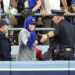 A law enforcement officer talks with a fan who reached over the outfield wall to catch a fly ball by New York Yankees' Gleyber Torres during the ninth inning in Game 1 of the baseball World Series, Friday, Oct. 25, 2024, in Los Angeles. (AP Photo/Godofredo A. Vásquez)