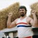 Geoff Capes holds straw bales