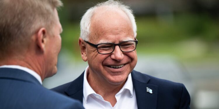 Tim Walz, man with white hair, smiling with black rimmed glasses