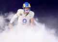 Rams quarterback Matthew Stafford runs through smoke during introductions before a home game.