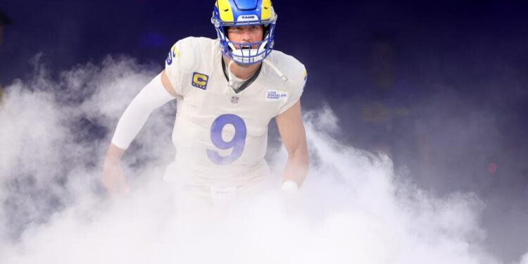 Rams quarterback Matthew Stafford runs through smoke during introductions before a home game.