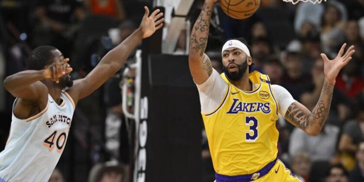 Los Angeles Lakers' Anthony Davis (3) grabs the rebound ahead of San Antonio Spurs' Harrison Barnes during the first half of an NBA basketball game, Wednesday, Nov. 27, 2024, in San Antonio. (AP Photo/Darren Abate)