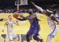 Los Angeles Lakers forward LeBron James, center, shoots as Oklahoma City Thunder center Isaiah Hartenstein, left, and guard Shai Gilgeous-Alexander defend during the first half of an Emirates NBA Cup basketball game, Friday, Nov. 29, 2024, in Los Angeles. (AP Photo/Mark J. Terrill)