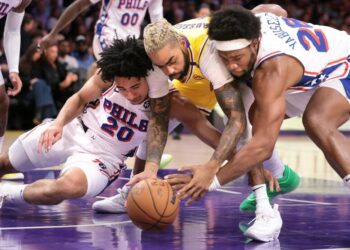 Lakers guard D'Angelo Russell battles 76ers Jared McCain and Guerschon Yabusele for a loose ball at Crypto.com Arena.