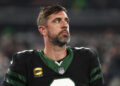 EAST RUTHERFORD, NEW JERSEY - OCTOBER 31: Aaron Rodgers #8 of the New York Jets stands on the sidelines during the national anthem prior to an NFL football game against the Houston Texans, at MetLife Stadium on October 31, 2024 in East Rutherford, New Jersey. (Photo by Kevin Sabitus/Getty Images)