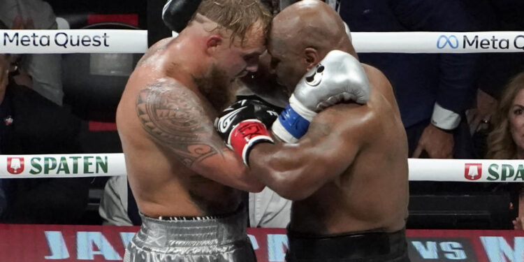 US YouTuber/boxer Jake Paul (L) and US retired pro-boxer Mike Tyson (R) hug at the end of their heavyweight boxing bout at The Pavilion at AT&T Stadium in Arlington, Texas, November 15, 2024. (Photo by TIMOTHY A. CLARY / AFP) (Photo by TIMOTHY A. CLARY/AFP via Getty Images)