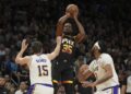 Suns forward Kevin Durant shoots over Lakers guard Austin Reaves and forward Anthony Davis Tuesday in Phoenix.