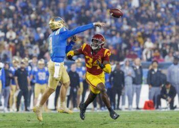 UCLA quarterback Ethan Garbers delivers a pass under pressure from USC defensive end Braylan Shelby at the Rose Bowl.