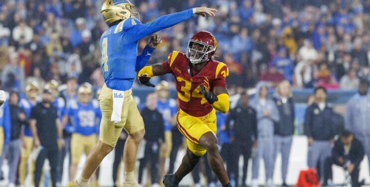 UCLA quarterback Ethan Garbers delivers a pass under pressure from USC defensive end Braylan Shelby at the Rose Bowl.