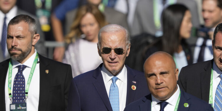 U.S. President Joe Biden arrives late for the group photo during the G20 Summit in Rio de Janeiro, Monday, Nov. 18, 2024. (AP Photo/Eraldo Peres)