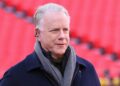 Boomer Esiason stands on the football field