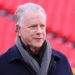 Boomer Esiason stands on the football field