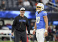 Los Angeles Chargers head coach Jim Harbaugh smiles next to quarterback Justin Herbert (10) before an NFL football game against the Cincinnati Bengals, Sunday, Nov. 17, 2024, in Inglewood, Calif. (AP Photo/Gregory Bull)