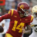 LOS ANGELES, CALIFORNIA - NOVEMBER 30: Quarterback Jayden Maiava #14 of the USC Trojans is chased out of the pocket by safety Xavier Watts #0 and defensive lineman Bryce Young #30 of the Notre Dame Fighting Irish during the first half at United Airlines Field at the Los Angeles Memorial Coliseum on November 30, 2024 in Los Angeles, California. (Photo by Kevork Djansezian/Getty Images)