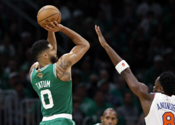 Boston, MA - October 22: Boston Celtics SF Jayson Tatum shoots a 3-point basket with pressure from New York Knicks SF OG Anunoby in the first quarter at TD Garden. (Photo by Danielle Parhizkaran/The Boston Globe via Getty Images)