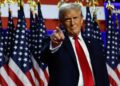 Donald Trump standing in front of American flags