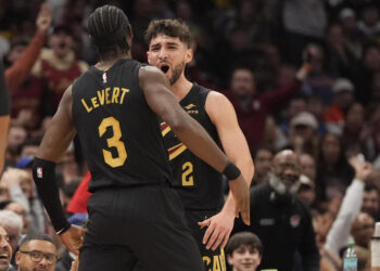 Cleveland Cavaliers guard Ty Jerome, right, celebrates a three-point basket with teammate Caris LeVert (3) in the first half of an NBA basketball game against the Golden State Warriors, Friday, Nov. 8, 2024, in Cleveland. (AP Photo/Sue Ogrocki)