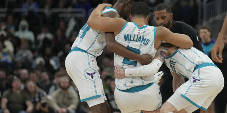 MILWAUKEE, WISCONSIN - NOVEMBER 23: Grant Williams #2 of the Charlotte Hornets helped by his teammates after being injured during the fourth quarter of a game against the Milwaukee Bucks at Fiserv Forum on November 23, 2024 in Milwaukee, Wisconsin. NOTE TO USER: User expressly acknowledges and agrees that, by downloading and or using this photograph, User is consenting to the terms and conditions of the Getty Images License Agreement. (Photo by Patrick McDermott/Getty Images)