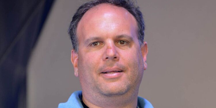 Mike Tannenbaum looks on