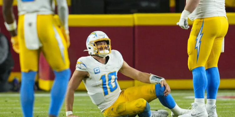 Dec 8, 2024; Kansas City, Missouri, USA; Los Angeles Chargers quarterback Justin Herbert (10) reacts after an injury during the first half against the Kansas City Chiefs at GEHA Field at Arrowhead Stadium. Mandatory Credit: Jay Biggerstaff-Imagn Images