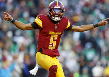 Dec 22, 2024; Landover, Maryland, USA; Washington Commanders quarterback Jayden Daniels (5) celebrates after throwing a touchdown during the fourth quarter against the Philadelphia Eagles at Northwest Stadium. Mandatory Credit: Peter Casey-Imagn Images