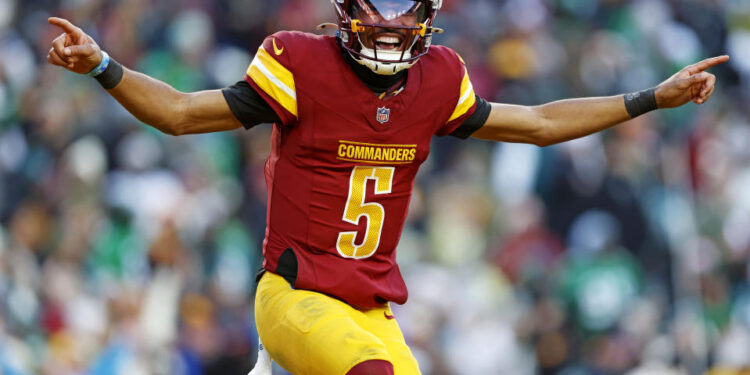 Dec 22, 2024; Landover, Maryland, USA; Washington Commanders quarterback Jayden Daniels (5) celebrates after throwing a touchdown during the fourth quarter against the Philadelphia Eagles at Northwest Stadium. Mandatory Credit: Peter Casey-Imagn Images