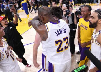 Lakers star LeBron James hugs teammate Austin Reaves after Reaves scored the winning basket against the Warriors.