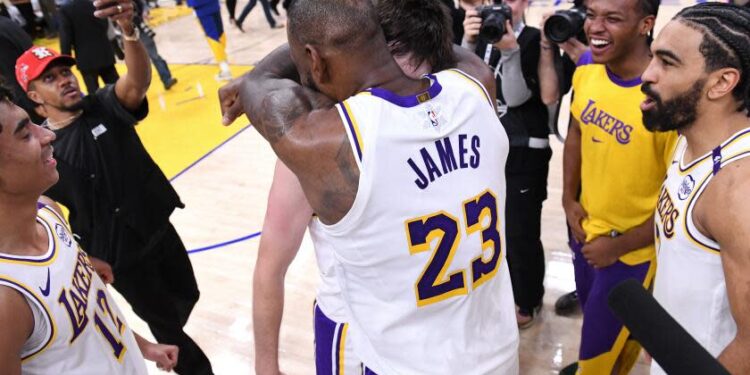 Lakers star LeBron James hugs teammate Austin Reaves after Reaves scored the winning basket against the Warriors.