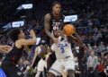 Inglewood, CA - December 28: Gonzaga guard Khalif Battle, center, #99, fouls UCLA guard/forward Eric Dailey.