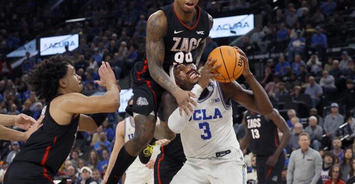 Inglewood, CA - December 28: Gonzaga guard Khalif Battle, center, #99, fouls UCLA guard/forward Eric Dailey.