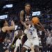 Inglewood, CA - December 28: Gonzaga guard Khalif Battle, center, #99, fouls UCLA guard/forward Eric Dailey.