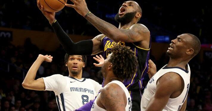 Los Angeles, CA - Lakers forward Lebron James drives to the basket against a trio of Grizzlies defenders.