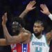 Philadelphia 76ers' Joel Embiid, left, tries to pass against Charlotte Hornets' Nick Richards during the first half of an NBA basketball game, Friday, Dec. 20, 2024, in Philadelphia. (AP Photo/Matt Slocum)