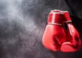 Pair of red boxing gloves hanging on the wall