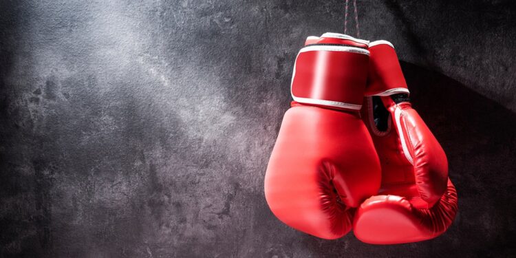 Pair of red boxing gloves hanging on the wall