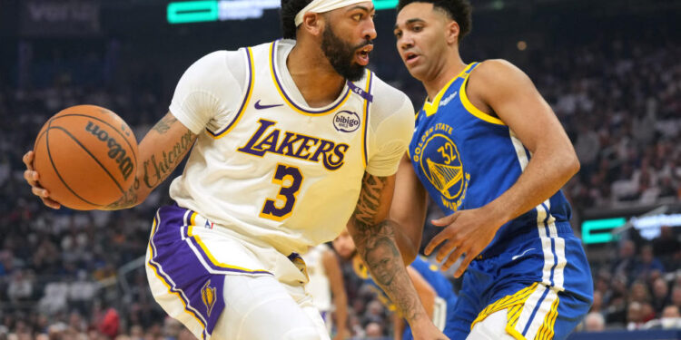 Dec 25, 2024; San Francisco, California, USA; Los Angeles Lakers forward Anthony Davis (3) dribbles against Golden State Warriors forward Trayce Jackson-Davis (32) during the first quarter at Chase Center. Mandatory Credit: Darren Yamashita-Imagn Images