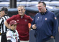 Illinois head coach Bret Bielema, right, and South Carolina head coach Shane Beamer chat on the field before the Citrus Bowl NCAA college football game, Tuesday, Dec. 31, 2024, in Orlando, Fla. (AP Photo/Phelan M. Ebenhack)